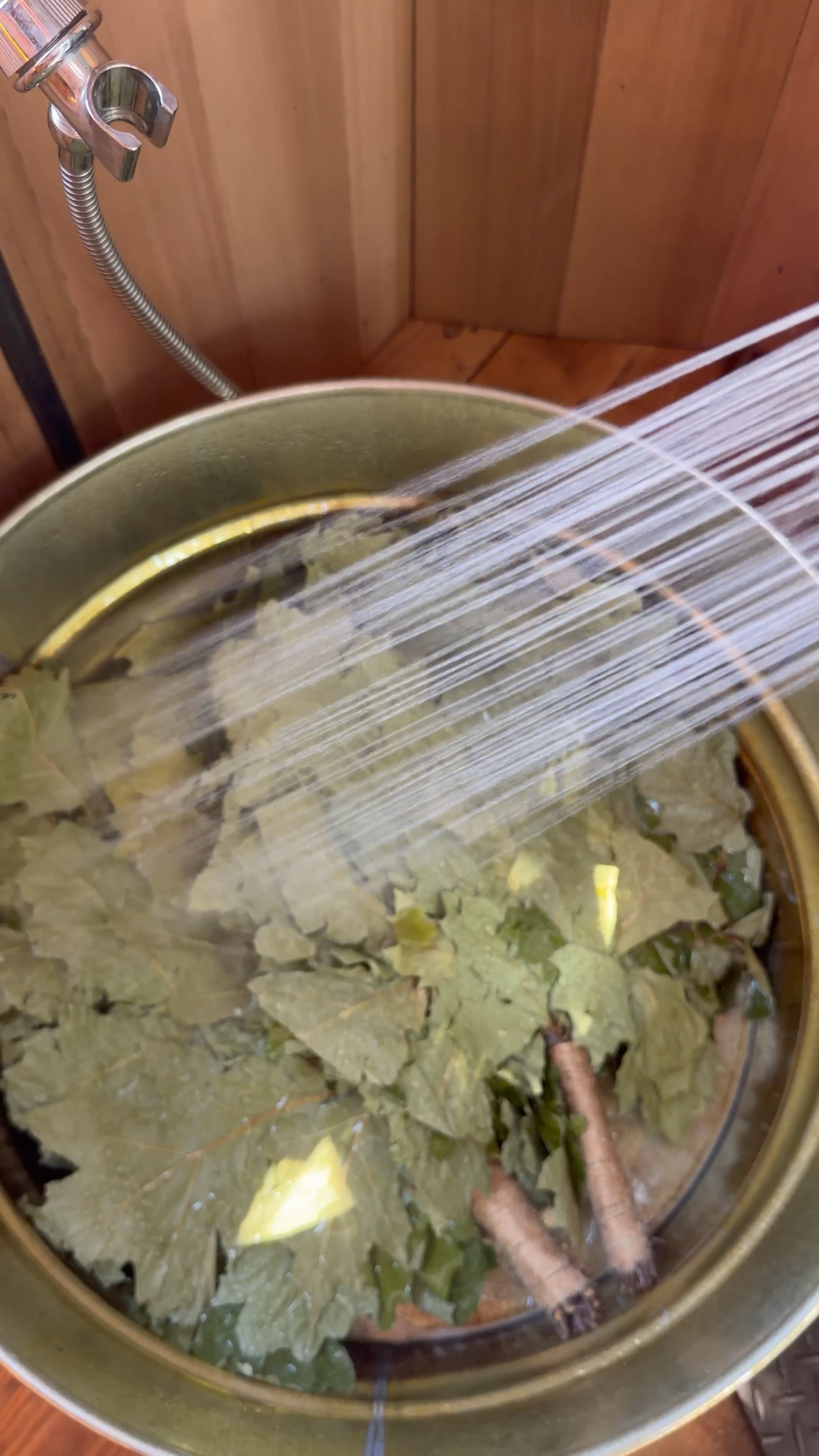 Water flowing over aromatic sauna whisks